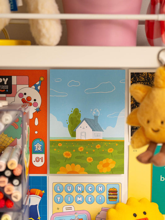 Art print on a wall with colorful illustrations on a shelf.