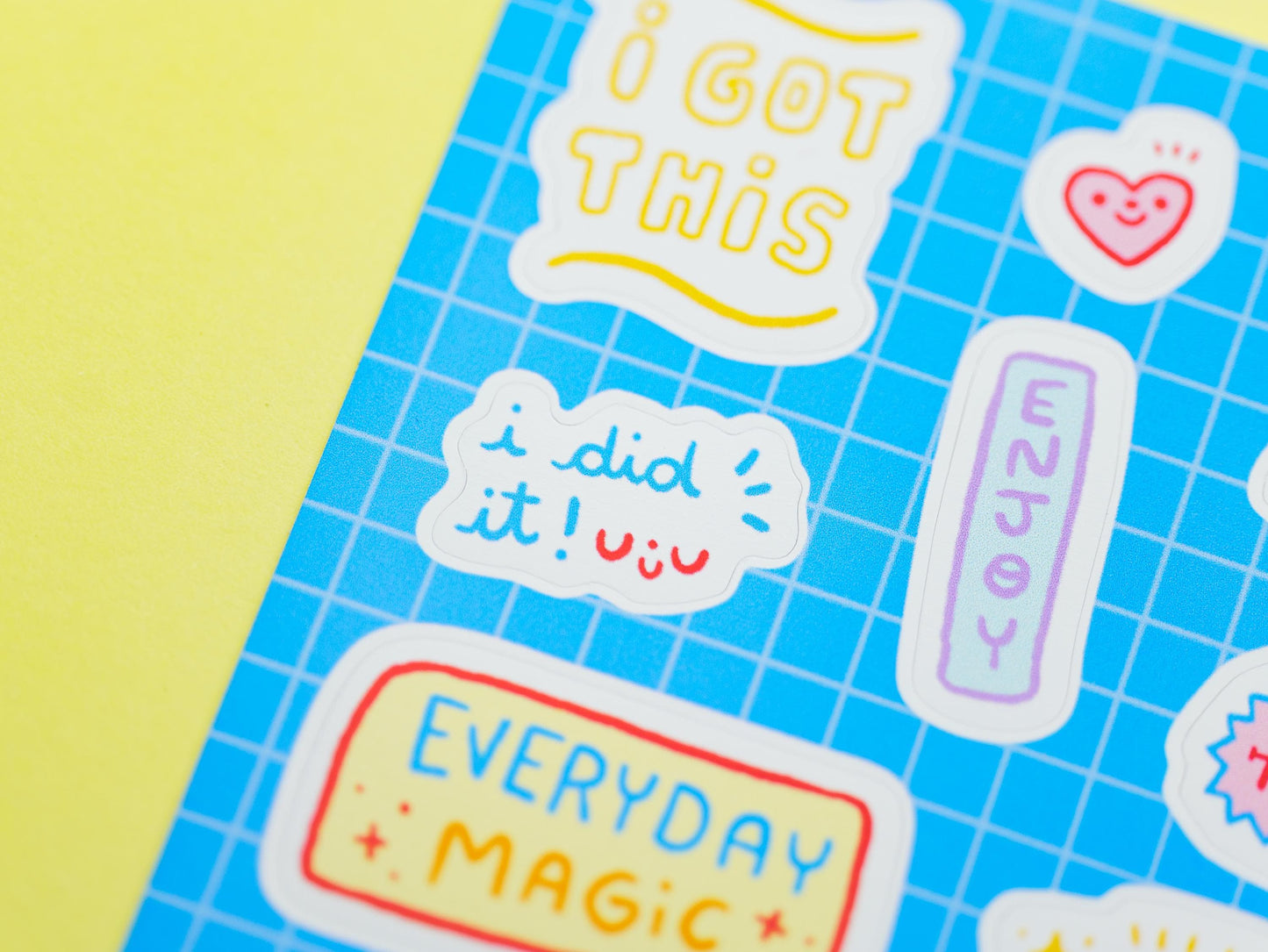 Motivational stickers on a blue grid background with a yellow border