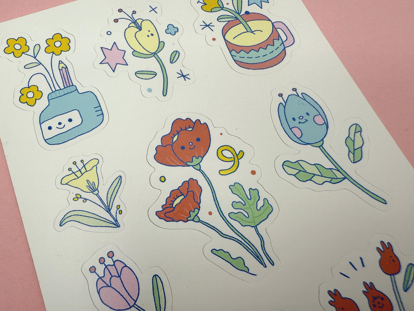 Colorful floral stickers on a white sheet with a pink background