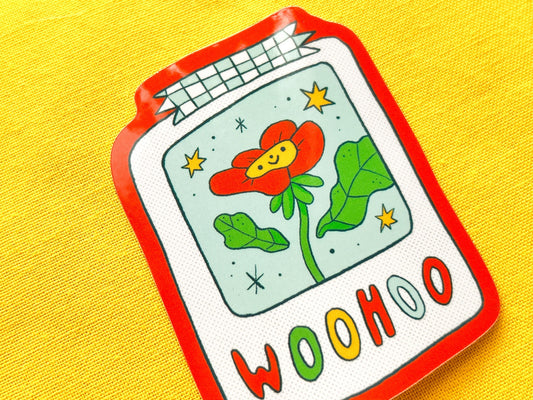 Colorful sticker of a polaroid with a flower and 'WOOHOO' text on a yellow background