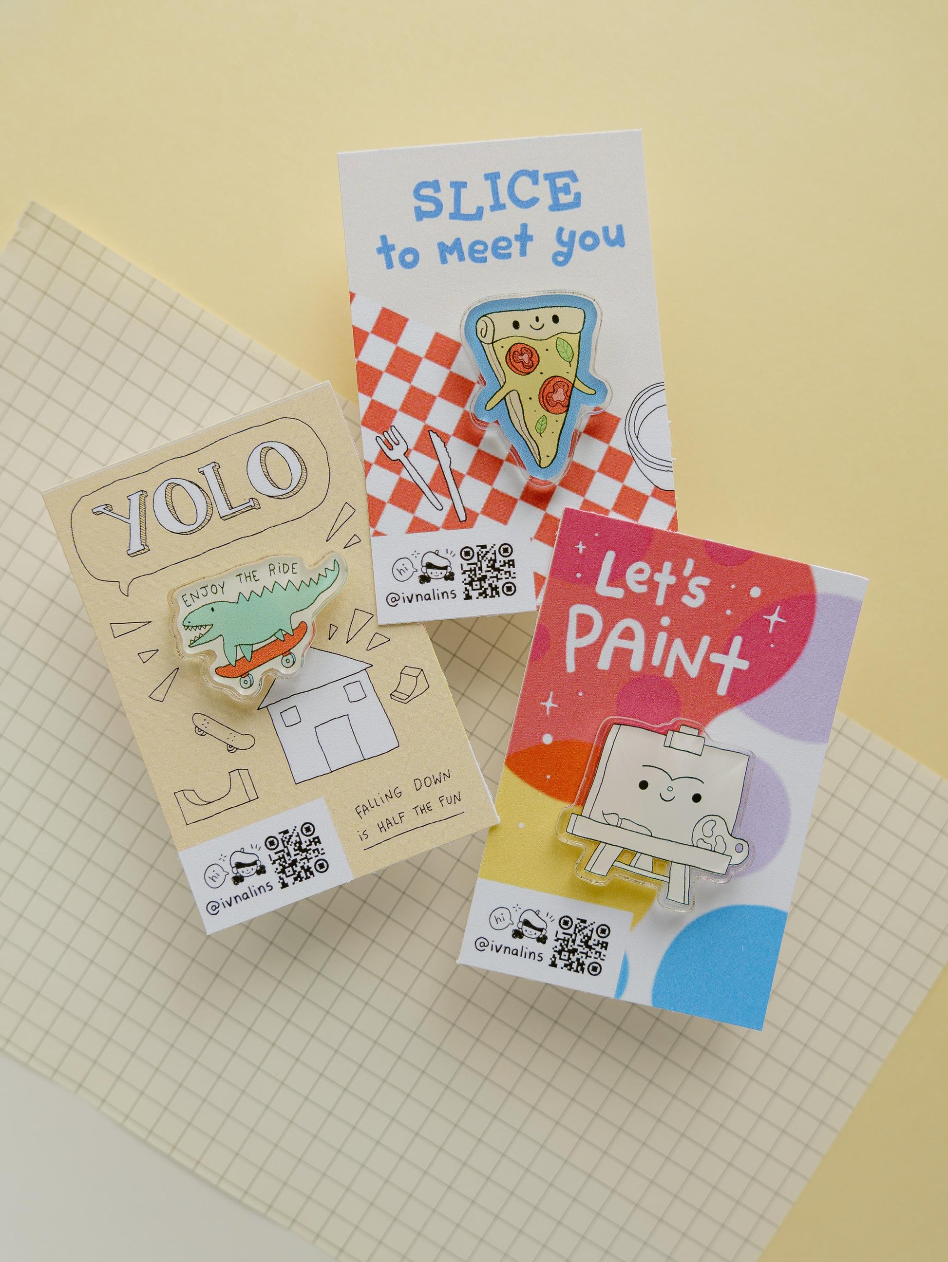 Three colorful pins with cards on a checkered surface