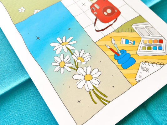 Postcard with daisy flowers and art supplies on a blue surface