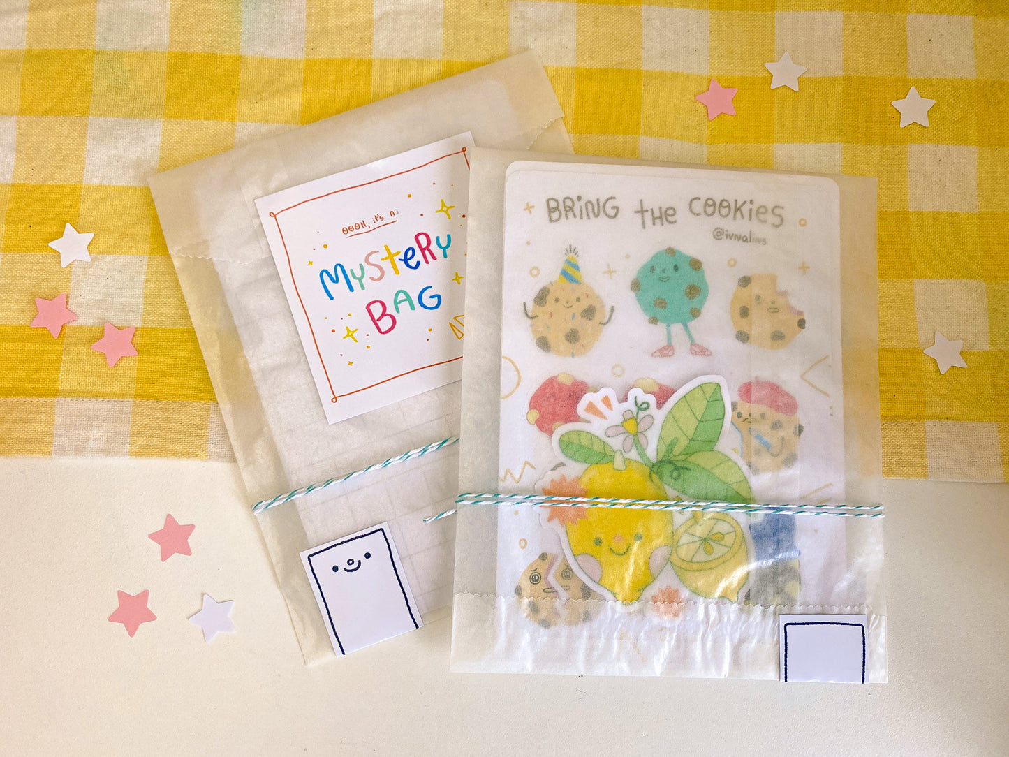 Packaged product with colorful stickers and cards on a yellow checkered background
