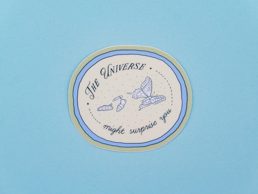 Circular sticker with text saying "the universe might surprise you" and illustrations of a catterpillar turning into a chrysalis and butterfly, on a blue background