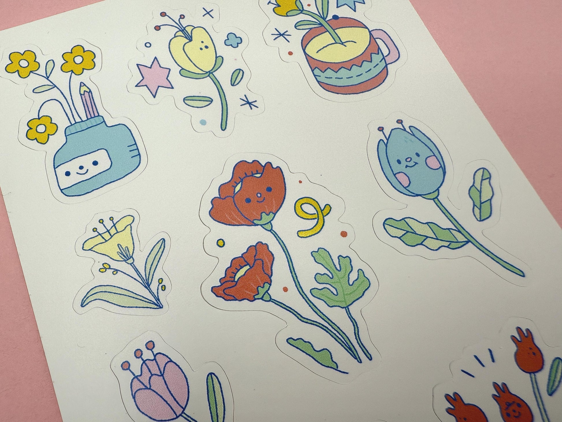 Colorful floral stickers on a white sheet with a pink background