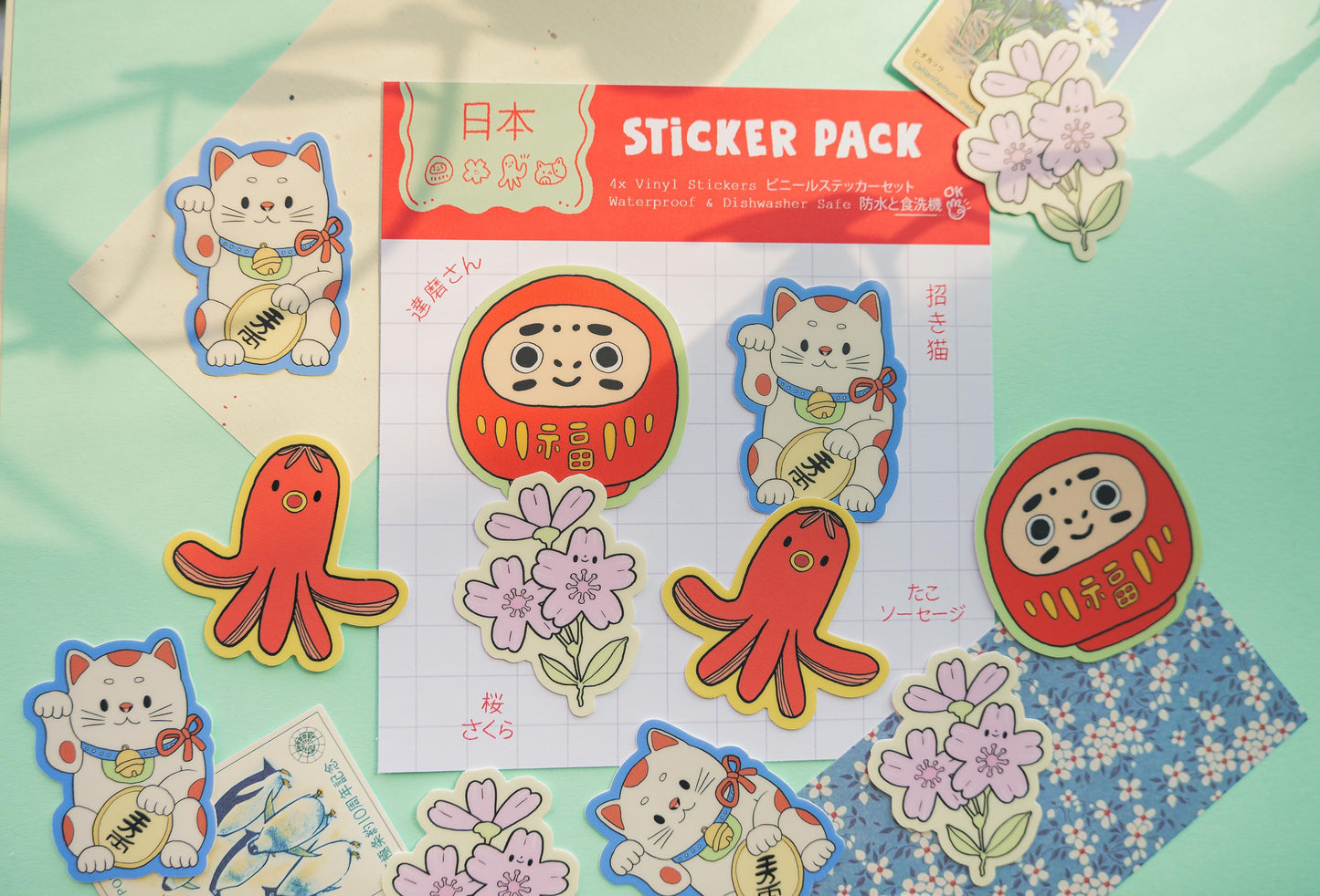 Sticker pack with cartoon characters on a colorful background. Daruma, Maneki-Neko, Sakura Flower and tako sausage