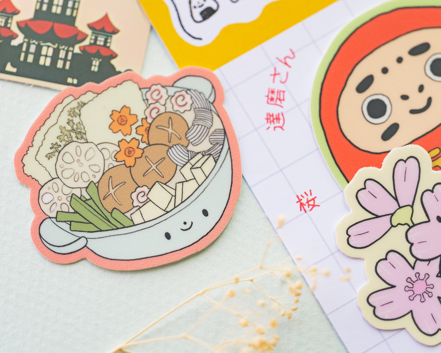 Colorful stickers featuring a bowl of soup, a cartoon character, and floral designs on a textured surface.
