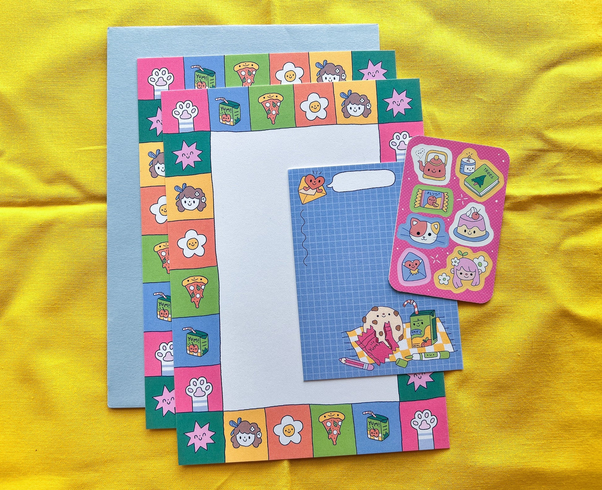 Colorful stationery set with stickers on a yellow fabric background