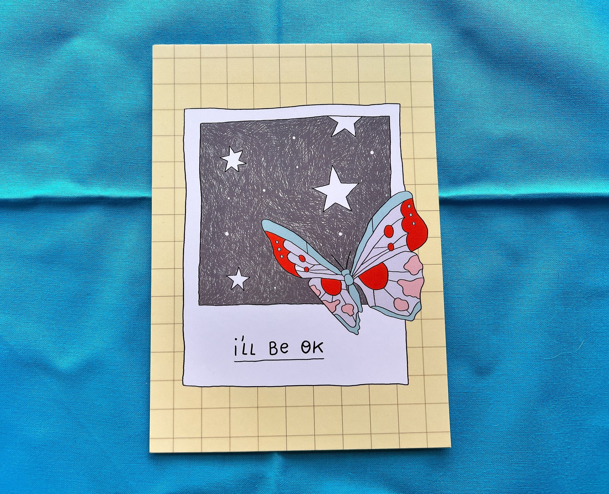 Card with a butterfly illustration and 'I'll be OK' text on a blue fabric background