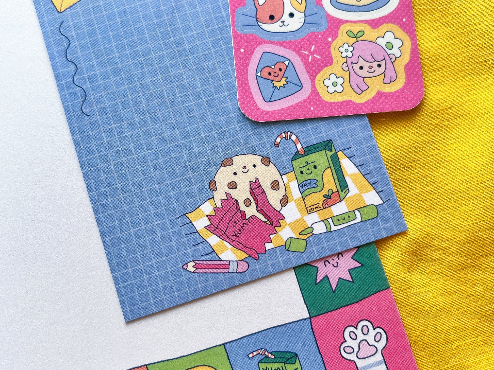 Colorful stickers on a blue grid paper and yellow background