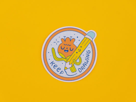 Circular sticker with cartoon character of a flower holding a pencil and text 'keep drawing' on a yellow background