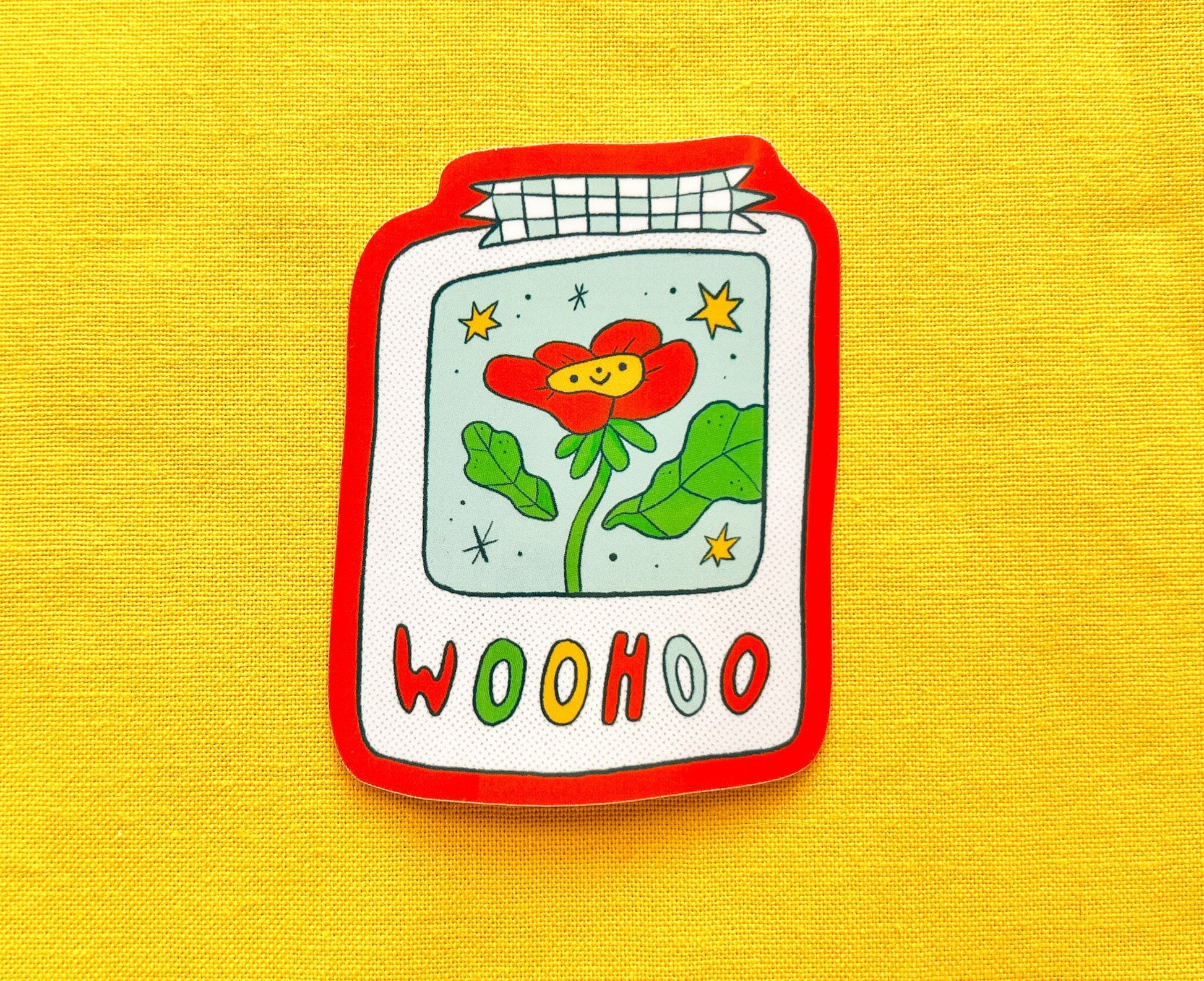 Sticker of a flower design and 'WOOHOO' text on a yellow background