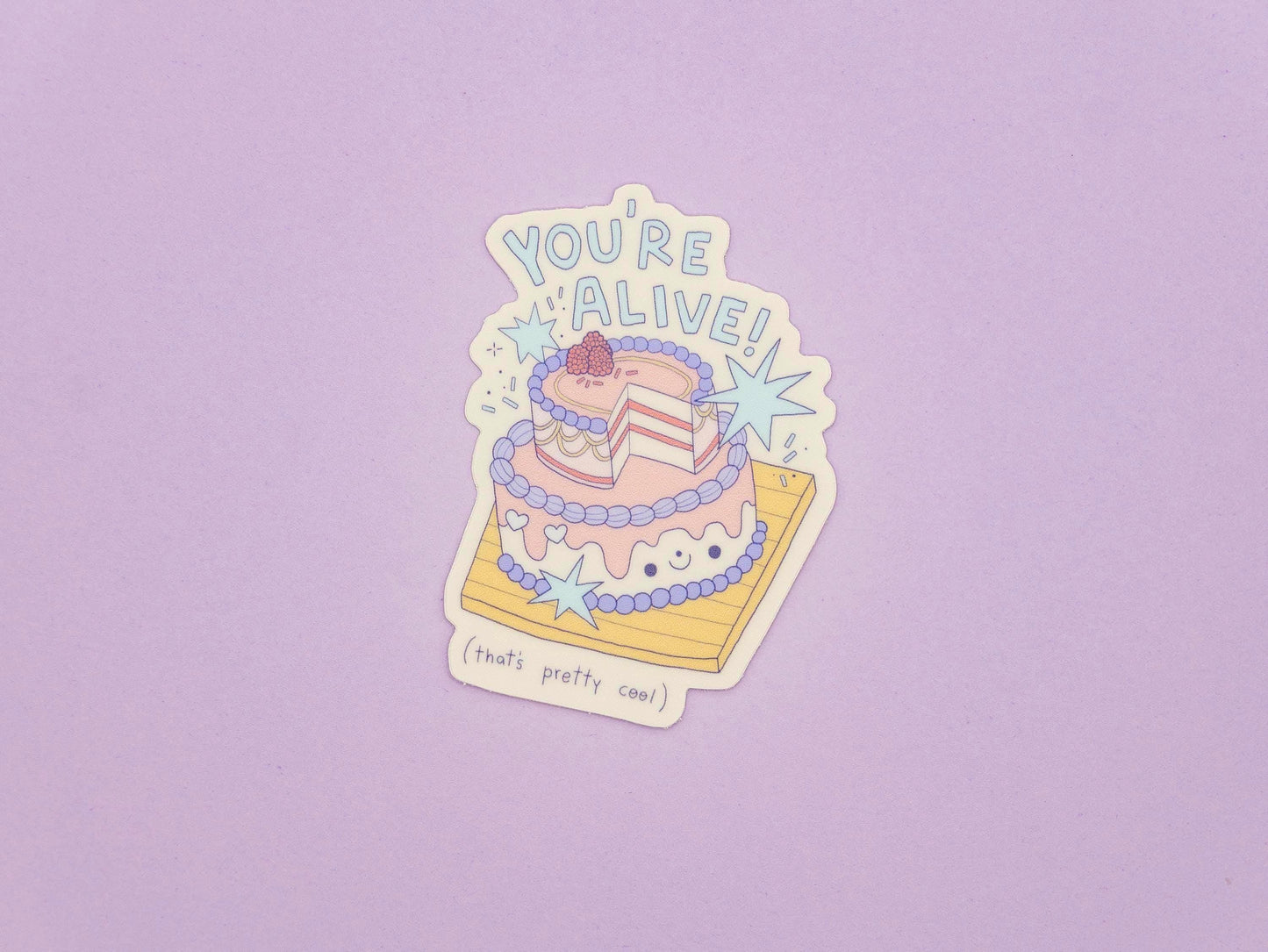 Sticker of a cake with 'You're Alive!' text on a purple background