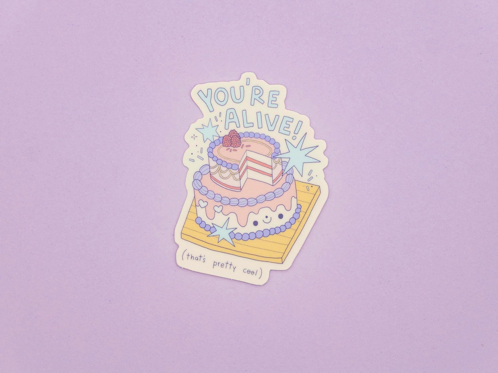 Sticker of a cake with 'You're Alive!' text on a purple background