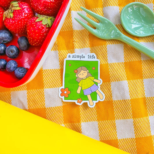Card with a girl illustration on a checkered tablecloth with strawberries and blueberries.