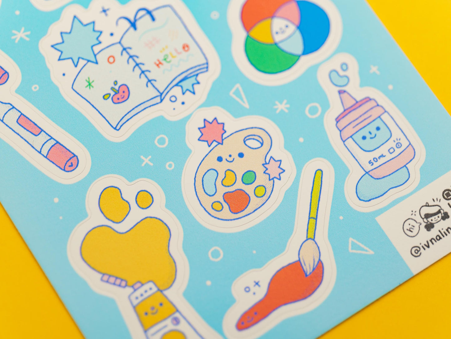 Stickers of art materials on a blue background with a yellow border